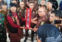 Ketua Umum Laskar Sasak Lalu Muhamad Ali Sadikin menyerahkan simbol gelar kehormatan adat Djero Pengkrakse Adhyaksa kepada Kepala Kejaksaan Tinggi NTB Wahyudi, S.H., M.H., sebagai bentuk dukungan masyarakat adat terhadap penegakan hukum, di Kantor Kejati NTB, Senin (19/1/2026).