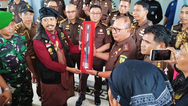 Ketua Umum Laskar Sasak Lalu Muhamad Ali Sadikin menyerahkan simbol gelar kehormatan adat Djero Pengkrakse Adhyaksa kepada Kepala Kejaksaan Tinggi NTB Wahyudi, S.H., M.H., sebagai bentuk dukungan masyarakat adat terhadap penegakan hukum, di Kantor Kejati NTB, Senin (19/1/2026).