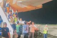 PMI asal Lombok Timur, Ahmad Saihu, tiba di Bandara Internasional Lombok dalam kondisi membutuhkan perawatan medis, dikawal Disnakertrans NTB sebelum dievakuasi ke RSUD Soedjono Selong.