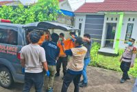 Petugas Pamapta Polres Dompu bersama Tim Inafis dan tenaga medis mengevakuasi jenazah korban dari lokasi kejadian di BTN Muezza Artaya Residence, Kelurahan Bada, Kecamatan Dompu, untuk dibawa menggunakan ambulans ke rumah sakit guna keperluan pemeriksaan medis dan penyelidikan lebih lanjut, Jumat (23/1/2026).