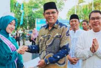 Bupati Sumbawa Ir. H. Syarafuddin Jarot, MP menyerahkan apresiasi berupa bantuan kepada Luthfiah Sabrina atas prestasinya di tingkat nasional, disaksikan jajaran ASN Pemkab Sumbawa.