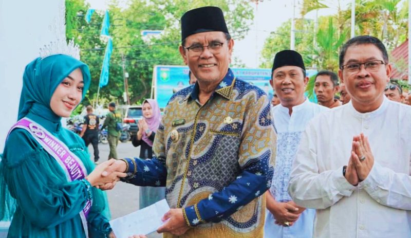 Bupati Sumbawa Ir. H. Syarafuddin Jarot, MP menyerahkan apresiasi berupa bantuan kepada Luthfiah Sabrina atas prestasinya di tingkat nasional, disaksikan jajaran ASN Pemkab Sumbawa.