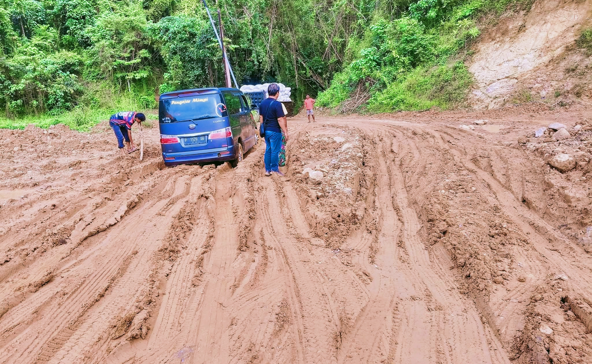 Mobil terjebak macet di jalan lenangguar lunyuk sumbawa akibat jalan rusak dan berlumpur