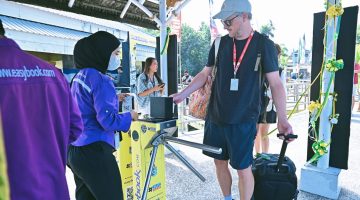 Terlihat seorang wisatawan asing saat memasuki Pelabuhan Senggigi menggunakan sistem e-ticketing sebagai bagian dari penerapan digitalisasi layanan transportasi wisata.