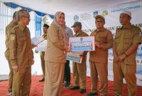 Wakil Gubernur NTB Indah Dhamayanti Putri atau akrab disapa Umi Dinda didampingi Sekda NTB Abul Chair menyerahkan dana kompensasi kepada delapan desa lingkar TPA Regional Kebon Kongok pada peringatan Hari Lingkungan Hidup Sedunia 2026.
