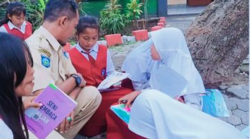 Sejumlah siswi sekolah dasar (SD) mengikuti kegiatan membaca buku di taman sekolah dengan pendampingan seorang guru. Hal ini menggambarkan upaya meningkatkan akses dan kualitas Pendidikan bagi anak-anak sebagai bagian dari pengurangan angka Anak Tidak Sekolah (ATS) di Lombok Barat.