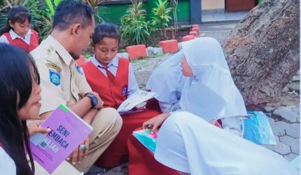 Sejumlah siswi SD membaca buku di taman sekolah didampingi seorang guru sebagai ilustrasi pendidikan dan upaya menekan angka Anak Tidak Sekolah (ATS) di Lombok Barat.
