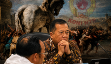 Gubernur NTB Lalu Muhamad Iqbal dengan latar ilustrasi Kuda Troya, Menggambarkan Sorotan Mi6 terhadap Dinamika Pencalonan Ketua KONI NTB Periode 2026-2030.