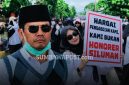 Bupati Dompu Bambang Firdaus Dengan Latar Aksi Ratusan PPPK Paruh Waktu Nakes dan Tenaga Teknis yang Menuntut Kepastian Pengangkatan Menjadi PPPK Penuh Waktu.