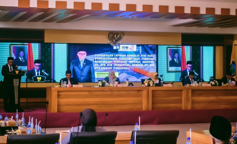 Akhdiansyah, SHI, Saat Membacakan Laporan Komisi III DPRD NTB Terkait Raperda Konversi PT BPR NTB menjadi PT BPRS NTB Bangkit Bersama Dalam Rapat Paripurna DPRD NTB.