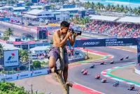 Seorang Warga Memotret Jalannya Balapan MotoGP Mandalika 2026 dari atas Pohon di Kawasan Sirkuit Mandalika, Lombok Tengah, NTB.