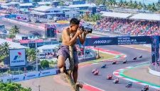Seorang Warga Memotret Jalannya Balapan MotoGP Mandalika 2026 dari atas Pohon di Kawasan Sirkuit Mandalika, Lombok Tengah, NTB.