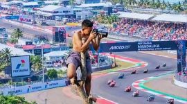 Seorang Warga Memotret Jalannya Balapan MotoGP Mandalika 2026 dari atas Pohon di Kawasan Sirkuit Mandalika, Lombok Tengah, NTB.