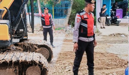 Bripka Arafe dari Polres Bima menimbun jalan provinsi berlubang di Desa Rabakodo, Kecamatan Woha, Kabupaten Bima.