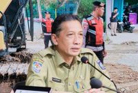 Bripka Arafe menimbun sementara jalan provinsi yang berlubang di Desa Rabakodo, Kecamatan Woha, Kabupaten Bima, sebagai upaya mengurangi risiko kecelakaan.