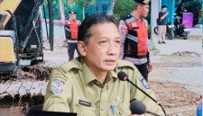 Bripka Arafe menimbun sementara jalan provinsi yang berlubang di Desa Rabakodo, Kecamatan Woha, Kabupaten Bima, sebagai upaya mengurangi risiko kecelakaan.