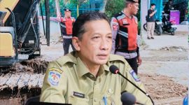 Bripka Arafe menimbun sementara jalan provinsi yang berlubang di Desa Rabakodo, Kecamatan Woha, Kabupaten Bima, sebagai upaya mengurangi risiko kecelakaan.